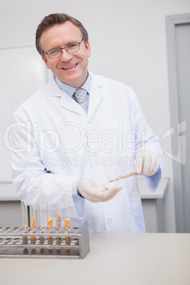Happy scientist holding kernel in tube