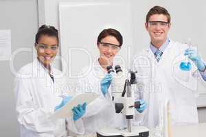 Scientists working attentively with microscope and beaker