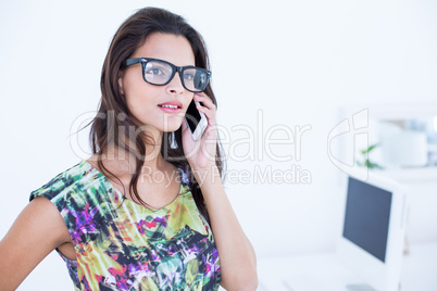 Smiling beautiful brunette standing in front of her computer