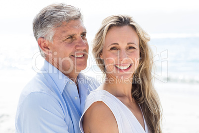 Happy couple standing by the sea and hugging each other