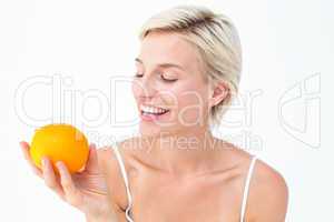 Happy woman holding an orange