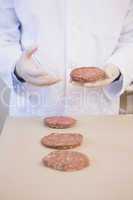 Scientist examining beefsteaks in petri dish