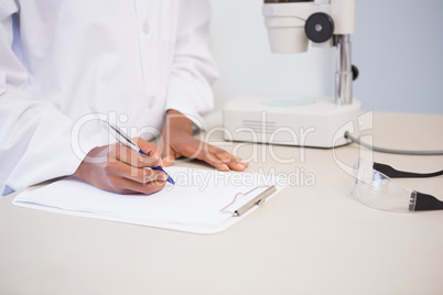 Concentrated scientist taking notes