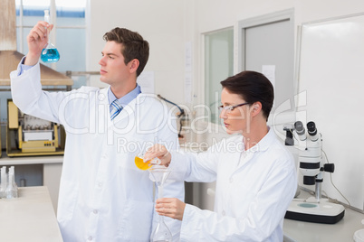 Scientists working attentively together with beakers