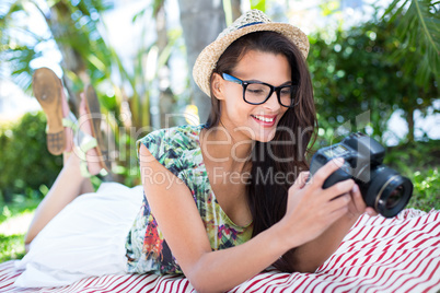 Smiling beautiful brunette lying on the blanket and taking pictu