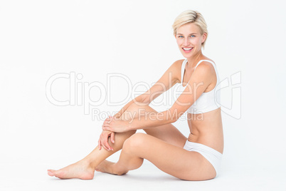 Pretty woman sitting on the floor smiling at the camera