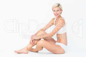 Pretty woman sitting on the floor smiling at the camera