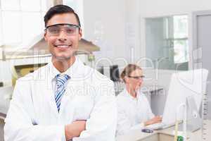 Smiling scientist looking at camera arms crossed