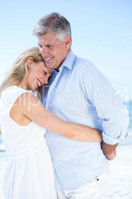 Happy couple standing by the sea and hugging each other