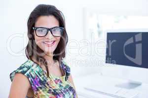 Smiling beautiful brunette sitting in front of her computer