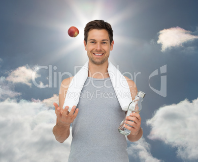 Composite image of smiling fit young man with apple and water bo