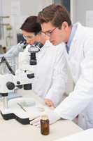 Scientists looking attentively in microscopes