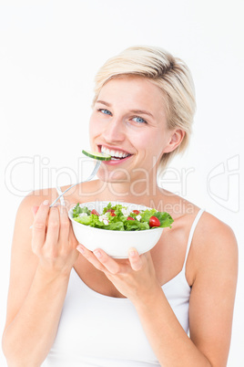 Beautiful blonde woman eating salad