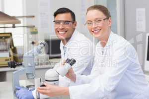 Happy scientists using microscope