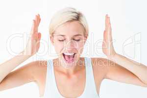 Happy blonde woman screaming with hands up