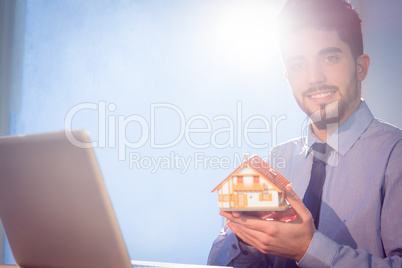 Businessman showing a mini house