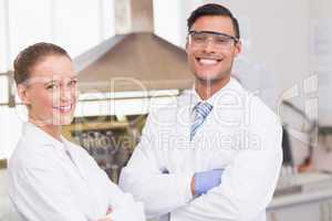 Happy scientists smiling at camera with arms crossed