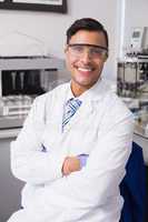 Happy scientist smiling at camera with arms crossed