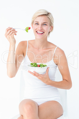 Beautiful blonde woman eating salad