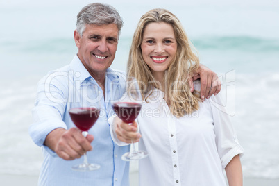 Happy couple smiling at camera and toasting