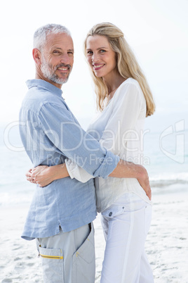 Happy couple hugging each other and looking at camera