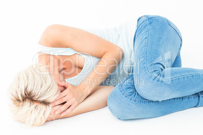 Sad blonde woman lying on the floor