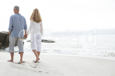 Happy couple walking by the sea