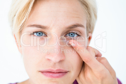 Pretty blonde applying contact lens