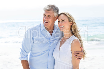 Happy couple standing by the sea