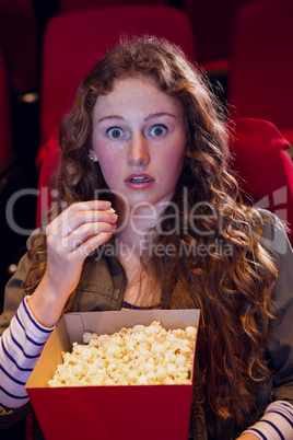 Surprised young woman watching a film