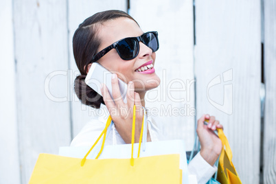 Pretty woman on the phone holding shopping bags