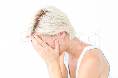 Sad blonde woman crying with head on hands