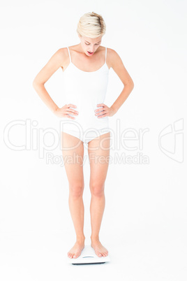 Blonde woman standing on weighing scales