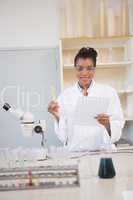 Smiling scientist looking at camera and holding paper