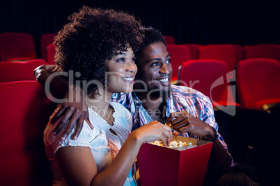 Happy young couple watching a film