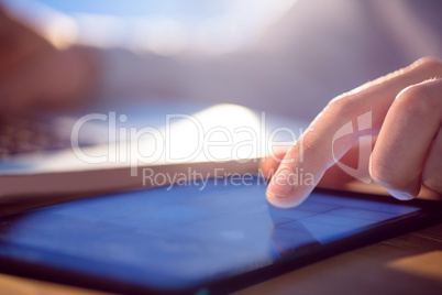 Businessman using laptop and tablet at desk