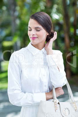 Happy woman posing with hand on bun