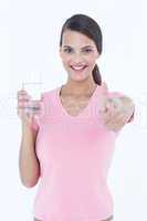 Beautiful woman drinking glass of water with thumb up