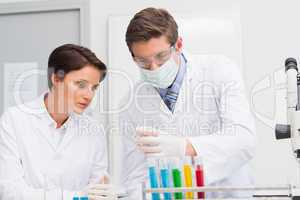 Scientists looking attentively at test tube