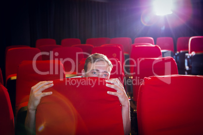 Young man watching a scary film