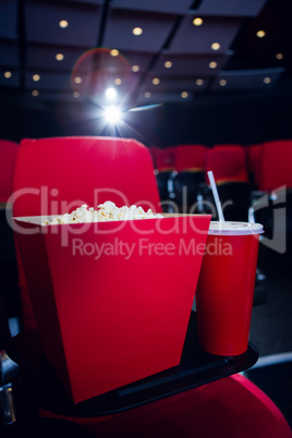 Empty rows of red seats with pop corn and drink