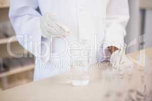 Scientist examining test tube and beaker