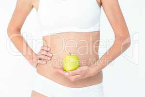 Woman holding an apple in front of her belly