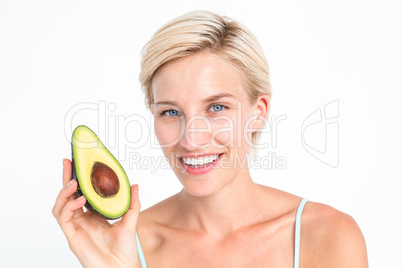 Pretty blonde holding half of an avocado