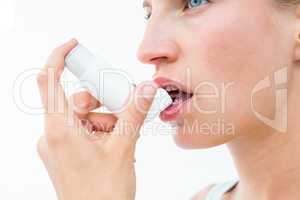 Blonde woman taking her inhaler