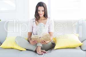 Smiling beautiful brunette relaxing and reading a book on the co