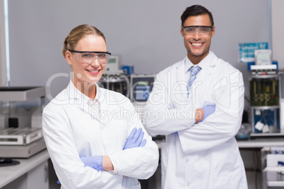 Smiling scientists looking at camera arms crossed