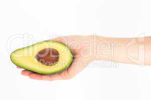 Woman presenting half of an avocado