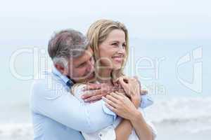 Happy couple hugging each other by the sea