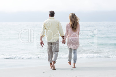 Happy couple walking by the sea